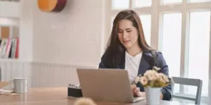 Woman sitting at a table working on a laptop